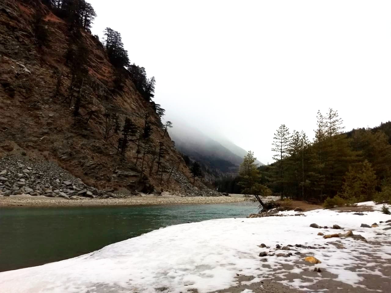 Bhagirathi river flows in the snow covered Harsil valley