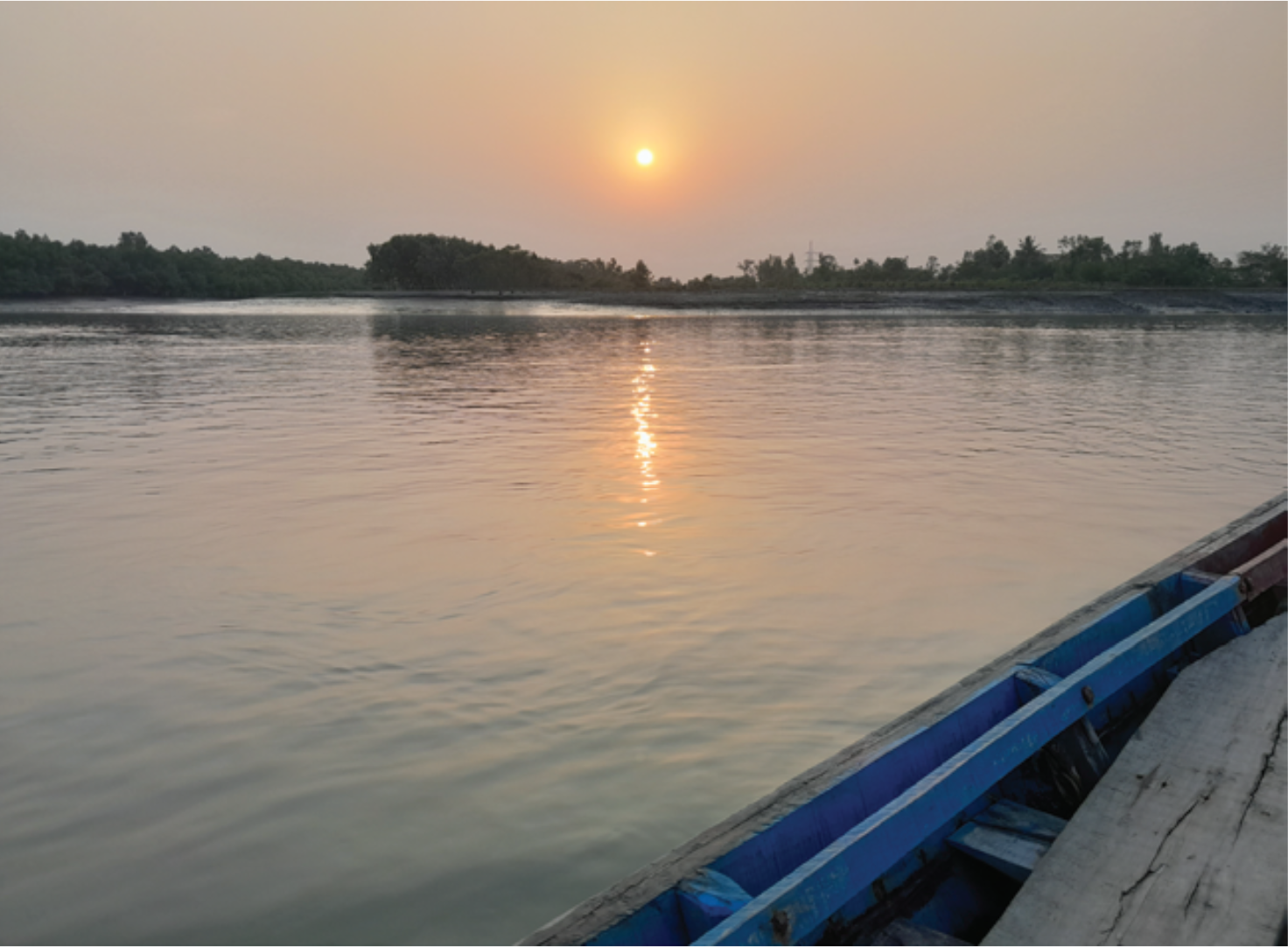 A beautiful sunset over the horizon creating little golden pools on the river